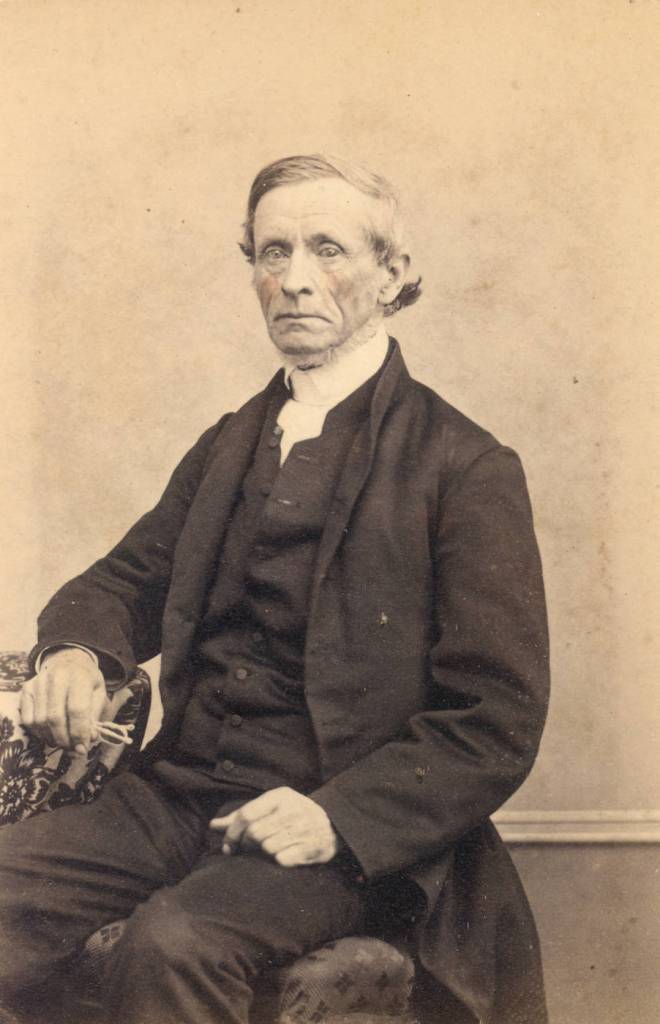 19th century quaker man sitting holding glasses